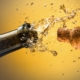 closeup of cork shooting out of a bottle of champagne