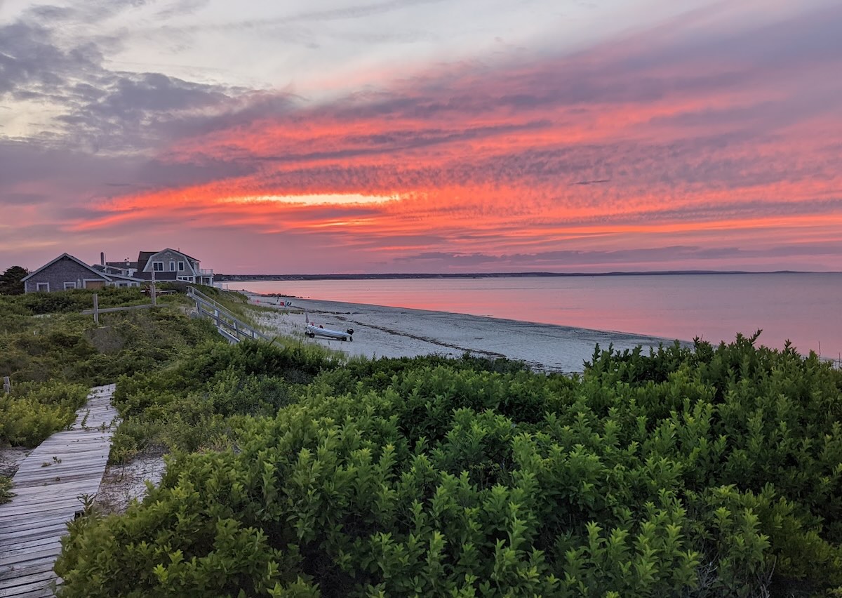 Wooden path over the dunes leading to a Cape Cod beach at sunset