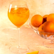 closeup of the Dubai Spritz mocktail with a bowl of oranges to the right of the cocktail