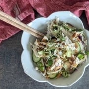 My Favorite Rotisserie Chicken Rice Bowl with Homemade Peanut Sauce 3 closeup of a rotisserie chicken rice bowl with a pair of chopsticks and a red and white cloth napkin