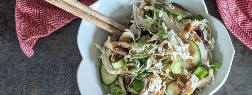 My Favorite Rotisserie Chicken Rice Bowl with Homemade Peanut Sauce 1 closeup of a rotisserie chicken rice bowl with a pair of chopsticks and a red and white cloth napkin
