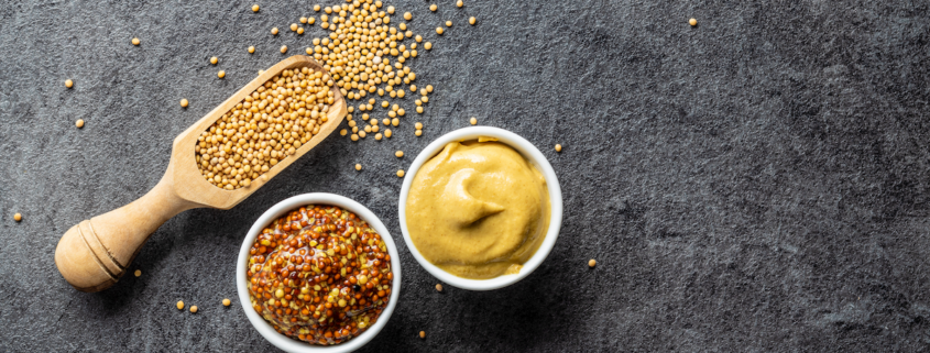 closeup of mustard seeds, coarse ground and yellow mustard on a black background