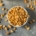 overhead shot of a bowl of roasted peanuts spilling out onto a gray countertop