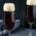two champagne flutes of black velvet Irish Champagne cocktails on a dark gray background