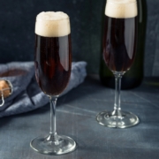two champagne flutes of black velvet Irish Champagne cocktails on a dark gray background