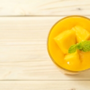 Morning Mango Nice Cream for a Healthy Start 3 Mango nice cream in a glass dish with chunks of ripe mango and a mint sprig garnish