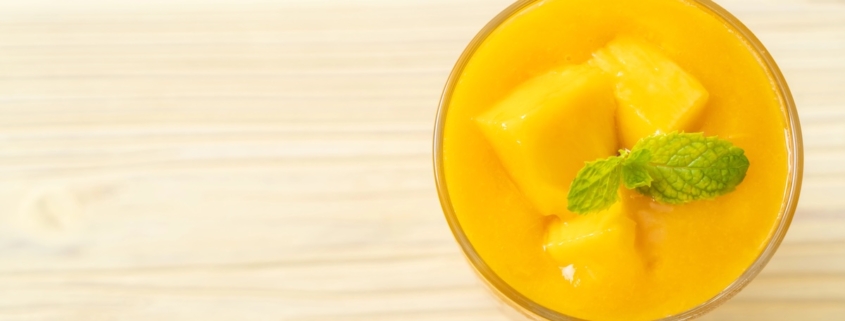 Morning Mango Nice Cream for a Healthy Start 1 Mango nice cream in a glass dish with chunks of ripe mango and a mint sprig garnish