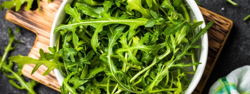 Arugula Benefits: How This Leafy Green Supports Sexual Health 1 clouseup of arugula leaves in a bowl on top of a wooden cutting board